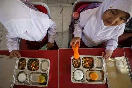 Sejumlah murid menyantap menu makanan di SDN Cilangkap 5, Depok, Jawa Barat, Senin (6/1/2025). Pemerintah resmi memulai Program Makan Bergizi Gratis yang dilaksanakan serentak di 26 Provinsi di Indonesia. JIBI/Bisnis/Arief Hermawan P