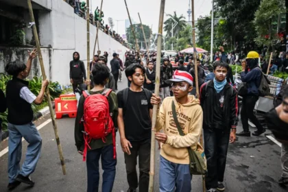 Sejumlah pengunjuk rasa membawa bambu saat melakukan aksi di Jalan Letjend S Parman, depan Gedung DPR, Jakarta, Senin (25/08). ANTARA FOTO/Bayu Pratama S