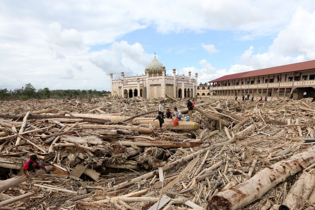 Petugas Kementerian Kehutanan dan Dinas Kehutanan Provinsi Aceh mengambil sampel kayu gelondongan yang terbawa arus luapan Sungai Tamiang, di area pasantren Islam Terpadu Darul Mukhlishin, Desa Tanjung Karang, Aceh Tamiang, Aceh, Jumat (19/12/2025). Kemenhut telah mengirim tim verifikasi dan membentuk tim investigasi gabungan bersama Polri untuk menelusuri asal-usul kayu gelondongan yang ditemukan pascabencana banjir di Sumatera Barat, Sumatera Utara dan Provinsi Aceh. (ANTARA FOTO/Irwansyah Putra)