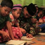 Foto: Anggota Satgas TMMD ke 99 mengajari anak-amak mengaji, SpiritNews.