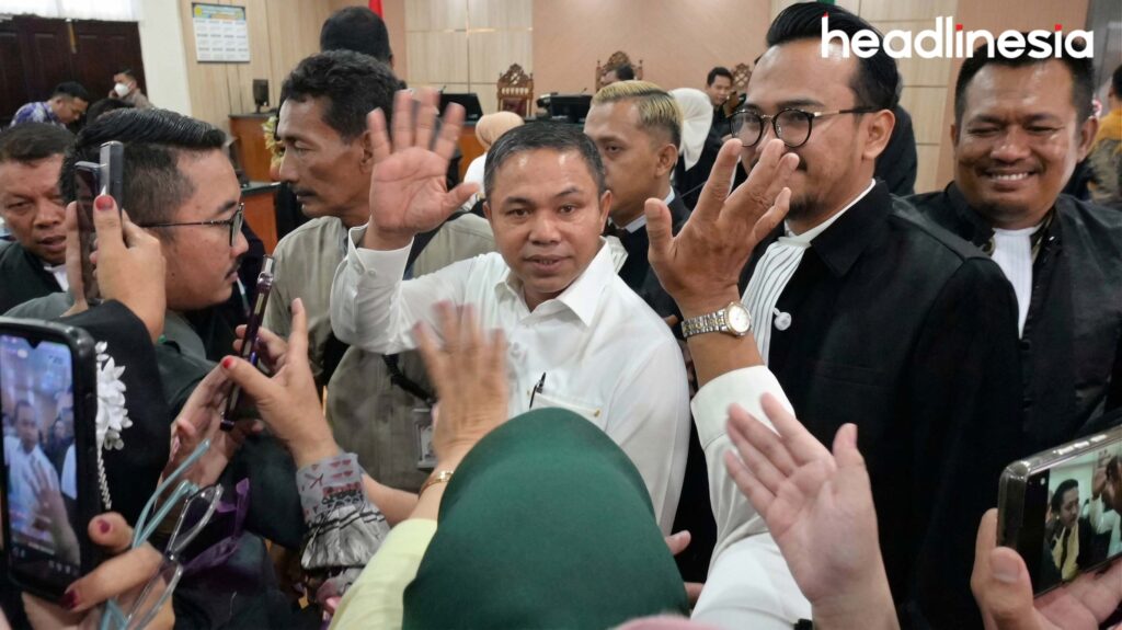 Gubernur Riau Berhalangan Sementara Abdul Wahid Melambaikan menyapa Masyarakat riau saat sidang perdana di Pengadilan Negeri Pekanbaru. headlinesia.com